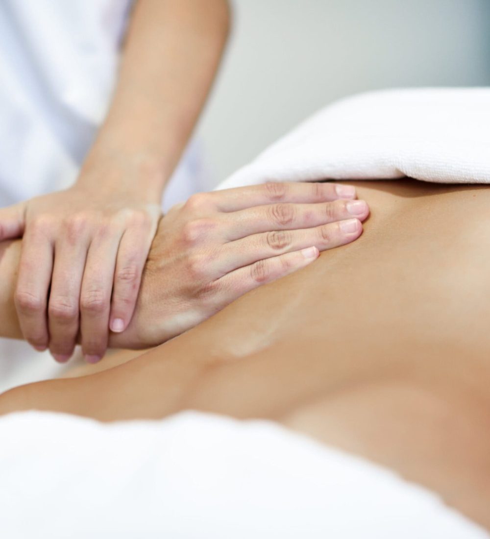 hands-massaging-female-abdomen-therapist-applying-pressure-on-belly-2-min-scaled(1)